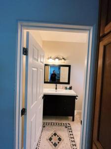 a bathroom with a sink and a person in a mirror at OB Paradise in San Diego