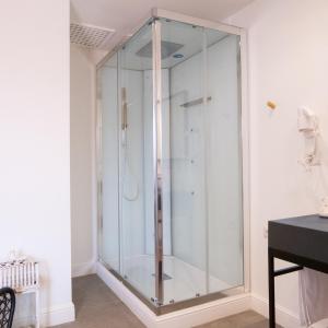 a glass shower in the corner of a room at Le Saline Beach Resort in Saline Joniche