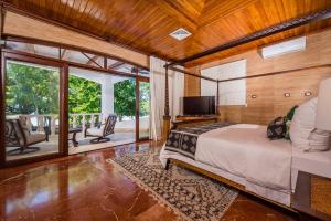 タマリンドにあるBlue Jewel Oceanfront Private Villaのベッドルーム1室(ベッド1台付)、バルコニー(テレビ付)