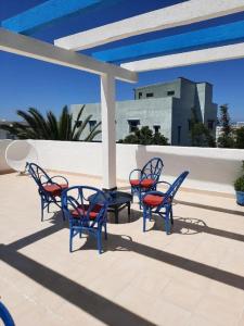 - un ensemble de chaises bleues assises sur une terrasse dans l'établissement MAISON D HÔTES Marine KSAR SGHIR, à Ksar Sghir