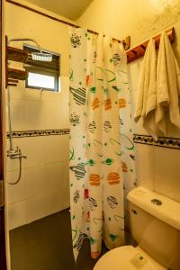 a bathroom with a shower curtain and a toilet at MISE CAVE LODGE in Kapchorwa