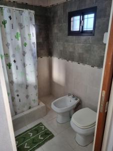 a bathroom with a toilet and a shower curtain at Monoambiente Gualeguaychú in Gualeguaychú