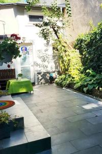 a patio with a green table and a building at Oasis Home-Garden Gem in The Heart of Bucharest in Bucharest