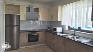 a kitchen with a stainless steel refrigerator and a sink at Casa Barbeiro in Pombal
