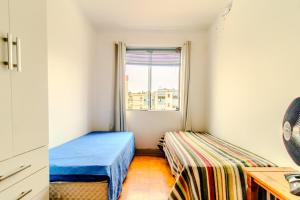a small room with two beds and a window at Apto com Wi Fi proximo ao centro Porto Alegre RS in Porto Alegre