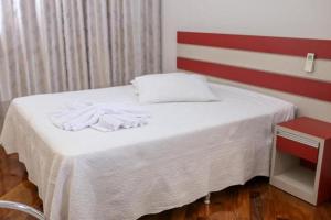 a bed with white towels on it in a room at Aconchego familiar in Foz do Iguaçu