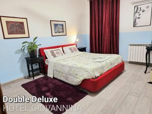 una camera da letto con un letto e un divano-letto rosso alla francese Sidx Sidx Sidx Sidx di Hotel Giovannina a Mestre