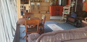 ein Wohnzimmer mit einem Holztisch und Stühlen in der Unterkunft Paradise Camp delux Rooms in Groutfontein