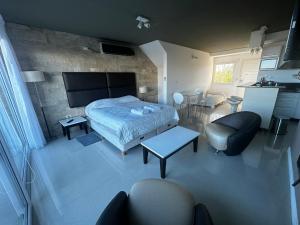 een slaapkamer met een bed en een woonkamer bij Linda Bay Spa Apartments in Mar de las Pampas
