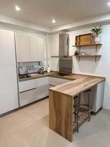 cocina con armarios blancos y encimera de madera en Fantástica vivienda situada el el corazón del Puerto de la Cruz, en Puerto de la Cruz