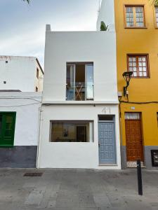 un edificio blanco con dos puertas y una ventana en Fantástica vivienda situada el el corazón del Puerto de la Cruz en Puerto de la Cruz
