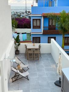 eine Terrasse mit Tisch und Stühlen auf einem Gebäude in der Unterkunft Fantástica vivienda situada el el corazón del Puerto de la Cruz in Puerto de la Cruz