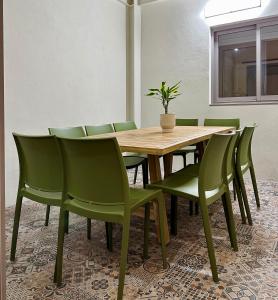 ein Holztisch und grüne Stühle in einem Raum in der Unterkunft Fantástica vivienda situada el el corazón del Puerto de la Cruz in Puerto de la Cruz
