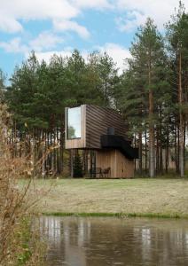a house with a large window on the side of a lake at Jägala Juga Nature Resort SPA 