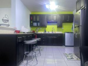 uma cozinha com armários pretos e paredes verdes em Beautiful 3-Bed House in Saint Catherine Portmore em Central Village