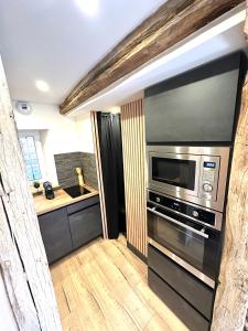 eine Küche mit einer Mikrowelle und einer Theke in der Unterkunft Maison Le Nid des Cigognes balnéothérapie pour 2 in Oberbronn