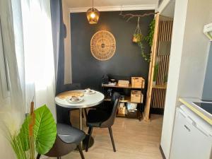 卢尔德[L’Écrin] Studio equipé avec vue panoramique的小型用餐室配有桌椅