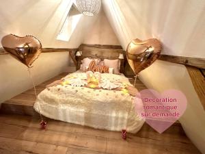 1 dormitorio con 1 cama con 2 globos cardiacos en Maison Le Nid des Cigognes balnéothérapie pour 2, en Oberbronn