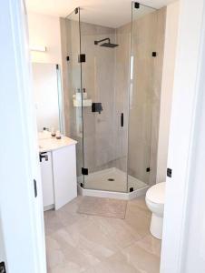a bathroom with a shower and a toilet and a sink at Centrally located, modern, 2 bedroom home in Vancouver
