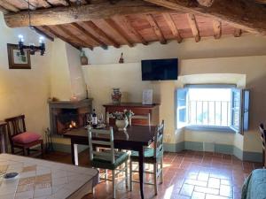 a dining room with a table and a fireplace at Casa tranquilla colonica toscana vicino a Firenze in Seano