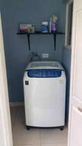 a small washing machine in a blue room at 1 Cozy Bedroom Apartment in Kingston