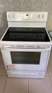 a white stove top oven sitting in a kitchen at 1 Cozy Bedroom Apartment in Kingston