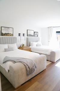 2 Betten in einem Schlafzimmer mit weißen Wänden und Holzböden in der Unterkunft Homestead Resort in Midway