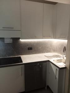 a kitchen with white cabinets and a sink at Dallo chef in Aosta