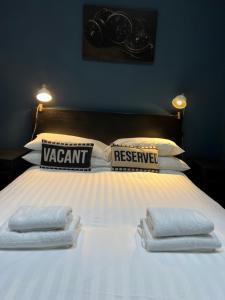 Una cama con tres toallas encima. en Stable Yard Rooms, en Richmond