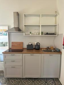 a kitchen with white cabinets and a sink at 15 Main Gate in Birgu