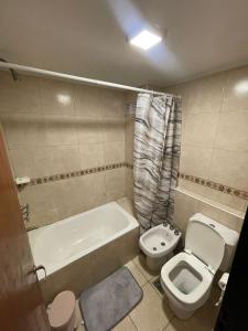 a bathroom with a toilet and a tub and a sink at Bv San Juan - Nva Cba in Córdoba +4 photos
