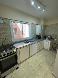 a kitchen with a stove and a sink and a window at Bv San Juan - Nva Cba in Córdoba