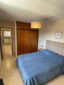 a bedroom with a bed with a blue blanket at Bv San Juan - Nva Cba in Córdoba