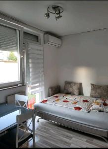 1 dormitorio con cama, mesa y ventana en Oaza mira, en Osijek