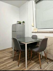 a dining room table with chairs and a refrigerator at Oaza mira in Osijek