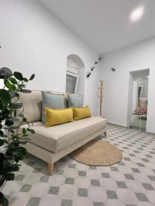 - un salon avec un canapé et des oreillers jaunes dans l'établissement Casa Abuela Ana, à Alcalá de los Gazules