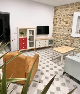 - un salon avec un canapé et une télévision dans l'établissement Casa Abuela Ana, à Alcalá de los Gazules