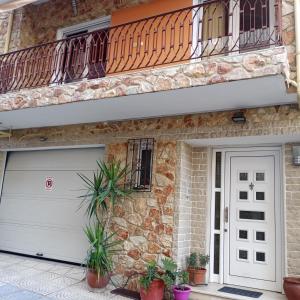 una casa con una puerta de garaje blanca y un balcón en STEVE'S HOUSE & ELDI en Edessa