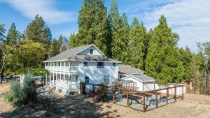 uma imagem de uma casa com árvores ao fundo em Inn at Sugar Pine Ranch em Groveland