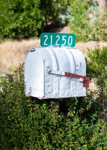 格羅夫蘭的住宿－Inn at Sugar Pine Ranch，灌木丛上带有街道标志的邮箱