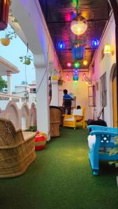 Manavi Hostel Near by Mathura Railway Station في ماثورا: غرفة ذات أرضية خضراء وأضواء على السقف