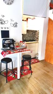 a kitchen with two stools and a table in a room at HOME SWEET HOME Vanini in Lecce