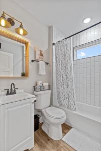 uma casa de banho com um WC, um lavatório e um chuveiro em Spacious Reimagined Home in Bevo Mill - JZ Vacation Rentals em Southhampton