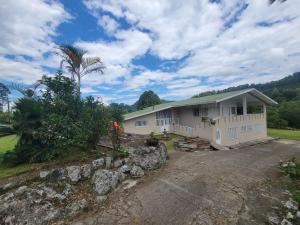 una casa con una palmera y un camino de entrada en Finca Margaritas, en Sasaima