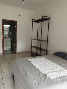 a bedroom with a bed with a shelf on the wall at Habitación privada en residencia CENTRO-NQN, baño ensuite in Neuquén