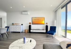 uma sala de estar com uma televisão na parede em Villa Céu e Mar em Prazeres