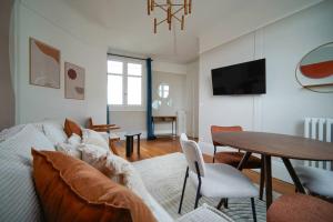 a living room with a couch and a table at Appartement Arc de Triomphe - Neuilly - II in Neuilly-sur-Seine