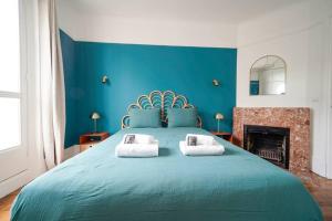 niebieska sypialnia z dużym łóżkiem z 2 poduszkami w obiekcie Appartement Arc de Triomphe - Neuilly - II w mieście Neuilly-sur-Seine