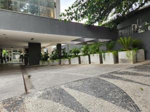 um edifício com um monte de plantas em frente dele em San Diego Express Barro Preto em Belo Horizonte