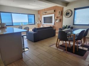 a living room with a couch and a table and chairs at Sunset Retreat at Bay Point in Cape Town